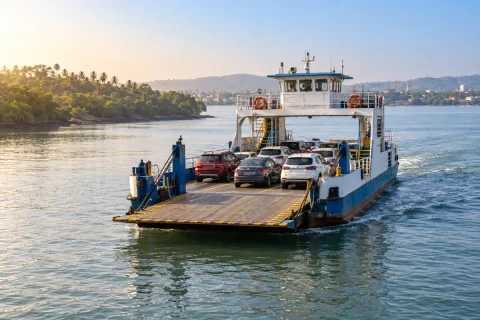 Vehicle ferry carrying cars across a calm creek