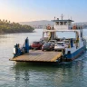Vehicle ferry carrying cars across a calm creek