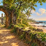 Stone arch and leafy ruins overlooking a palm-lined coast