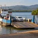 Car ferry beside a river landing and mangrove shoreline